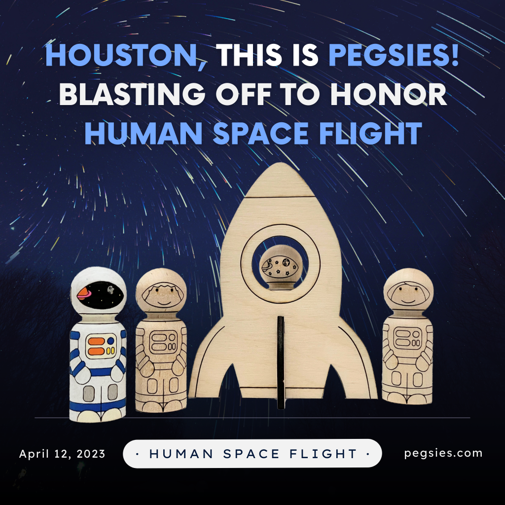 peg doll astronauts with wooden cutout spaceship on a background of shooting stars to honor international day of human space flight
